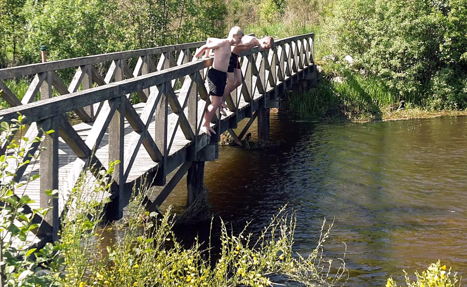 Sebastian og Tobias nyder at køle af i det svale klare åvand ved stemmeværkspladsen