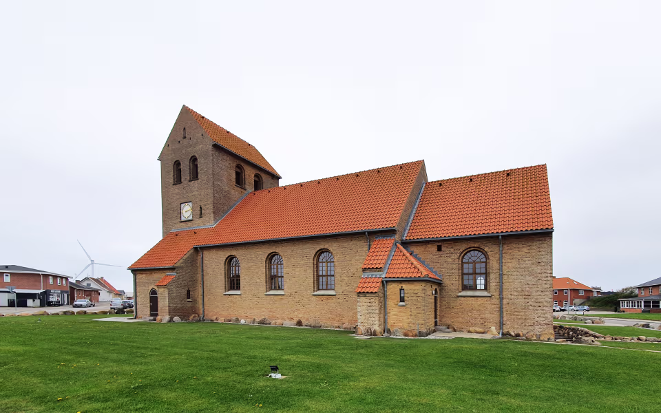 Helligåndskirken i Hvide Sande med teglrødt tag og grønt græs foran