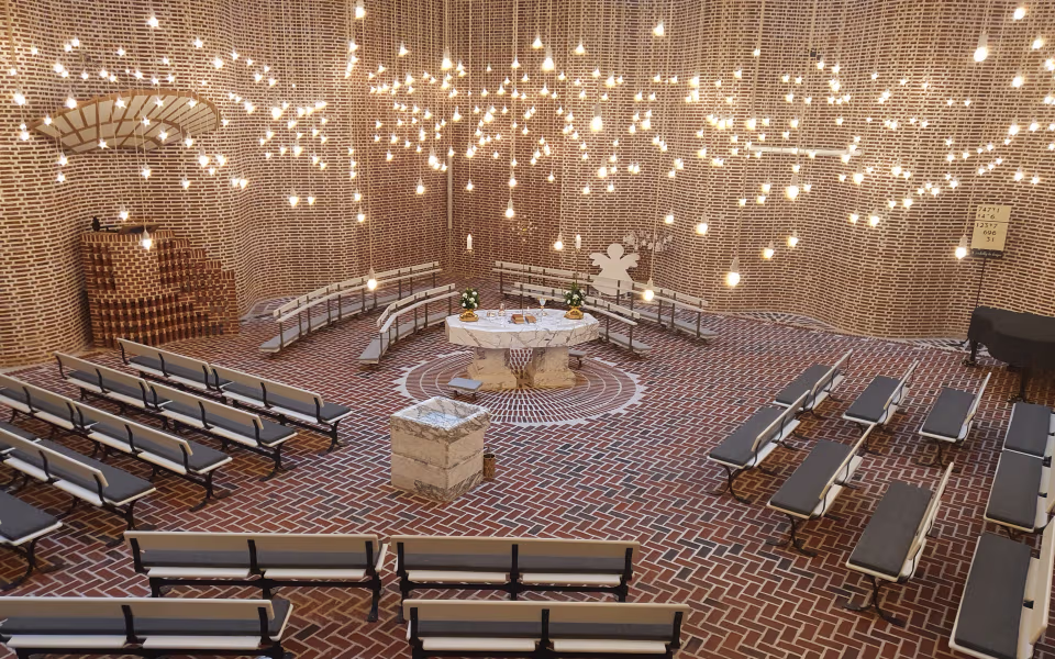 Lysekroner hænger over alter og bænke i Sædden Kirke