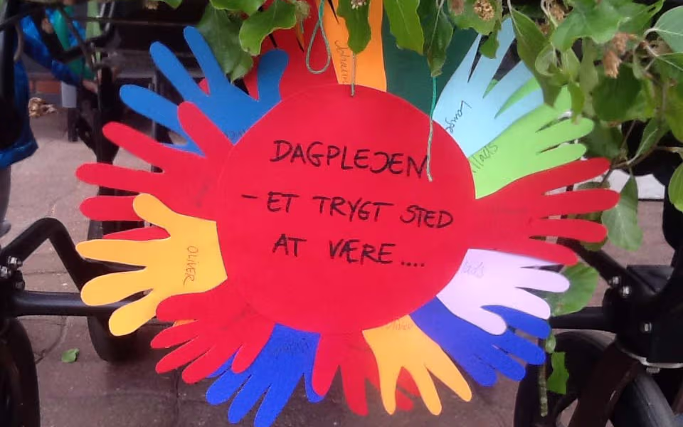Dagplejen på tur rundt i byen med blomsterpyntede vogne