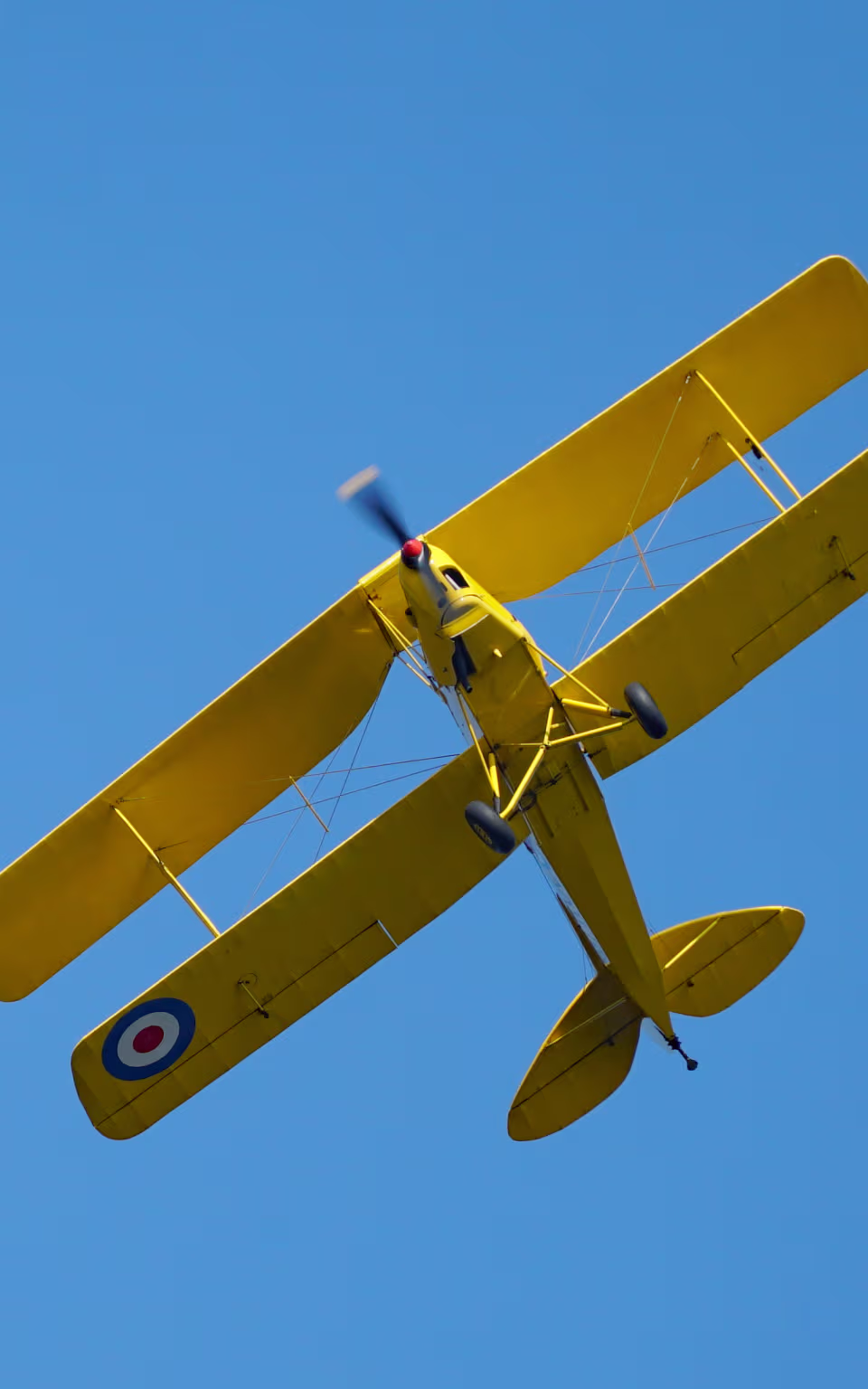 Gult dobbeltdækkerfly over West Jutland Airport i Stauning mod klar blå himmel