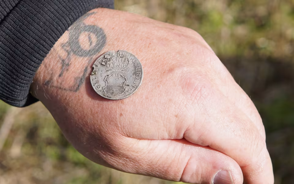 Per Olsen fandt lørdag en mortergranat med sin metaldetektor på marken mellem Tiphedevej og Kvie Søvej. En af bomberydderne viser granaten frem.
