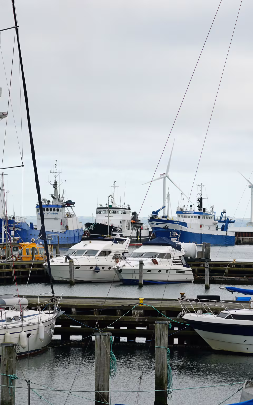 Fiskekuttere og sejlbåde ligger tæt ved kajen i Thyborøn havn
