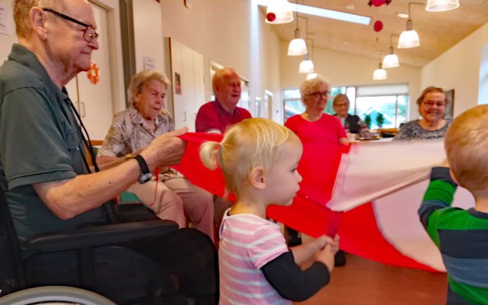 Dagplejebørn legede med den store faldskærm og balloner på Ansager Plejehjem