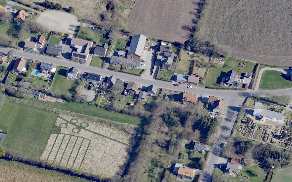 Landevej gennem Lydum med huse, marker og kirkegård ved ådalen