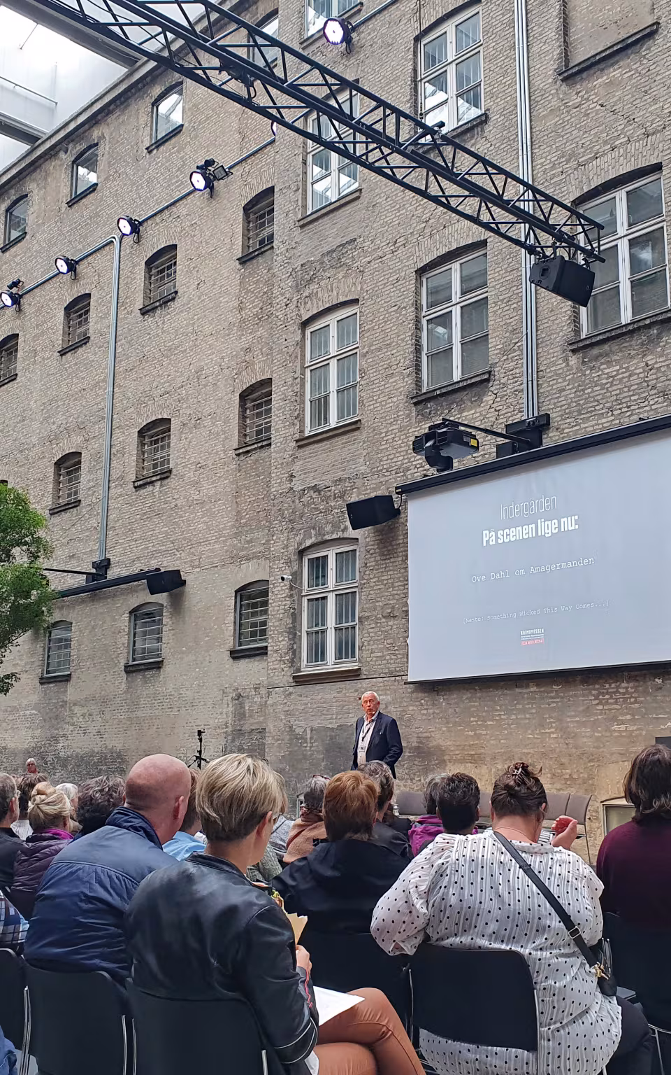 Publikum lytter til oplæg på scenen ved Krimimesse i Fængslet