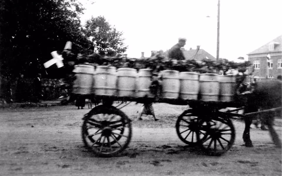 Mælkekuskenes parade med pyntede vogne gennem Ansager i anledning af mejeriets 50 års jubilæum passerer Torvet