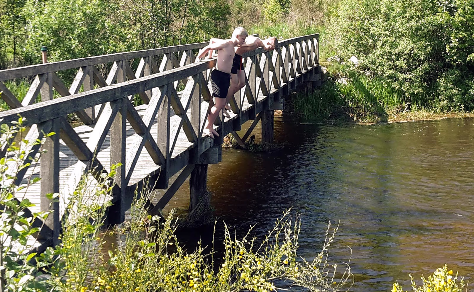 Sebastian og Tobias nyder at køle af i det svale klare åvand ved stemmeværkspladsen
