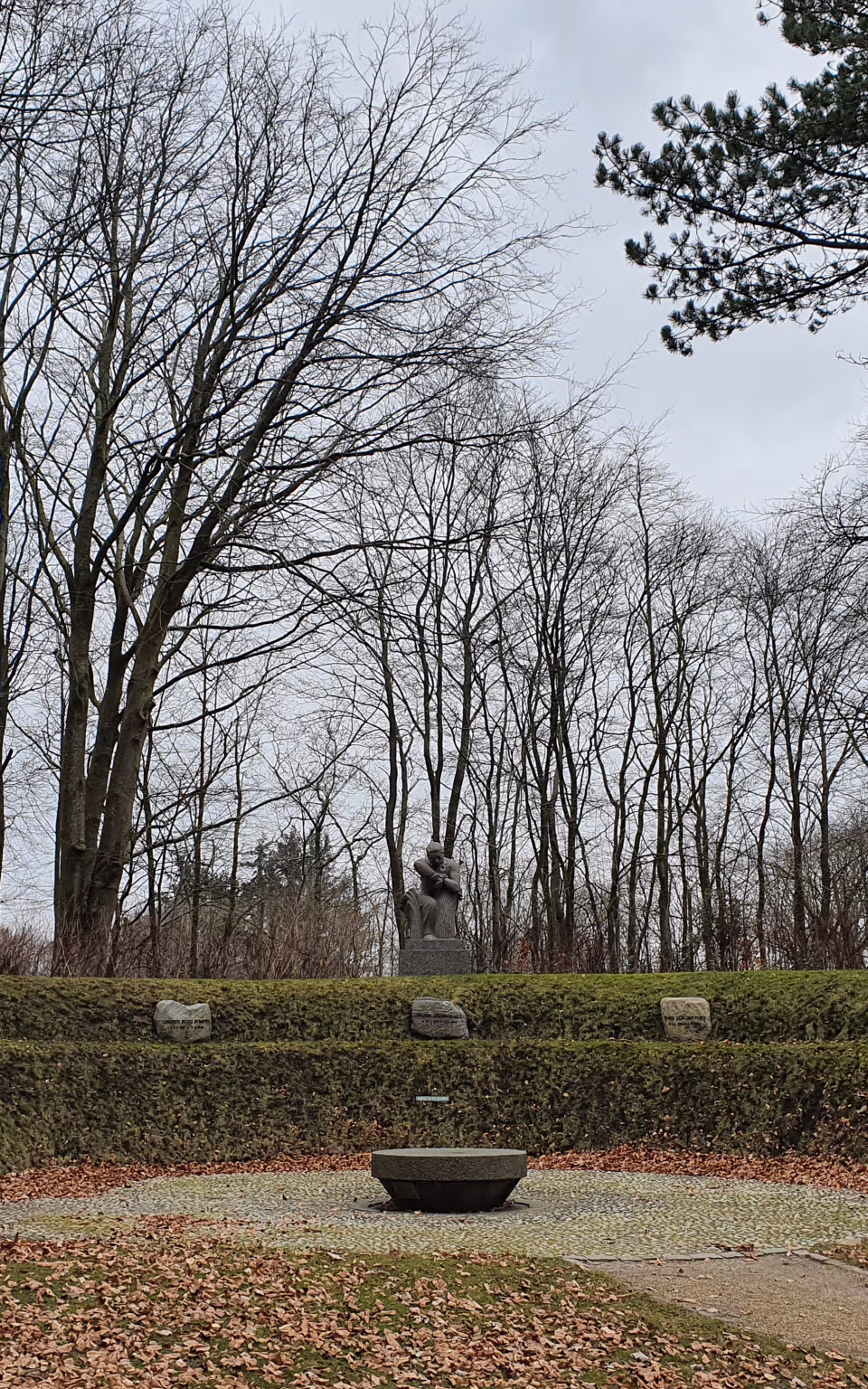 Statue blandt nøgne træer og mindesten i Arnbjergparken i Varde