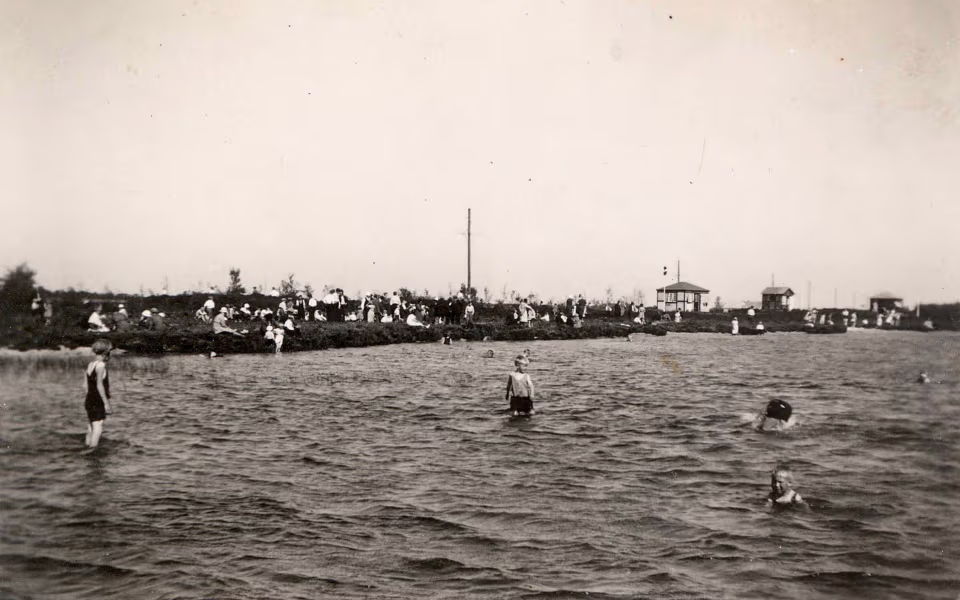 Badende gæster i Kvie Sø ved Hedens Riviera med mange mennesker på bredden