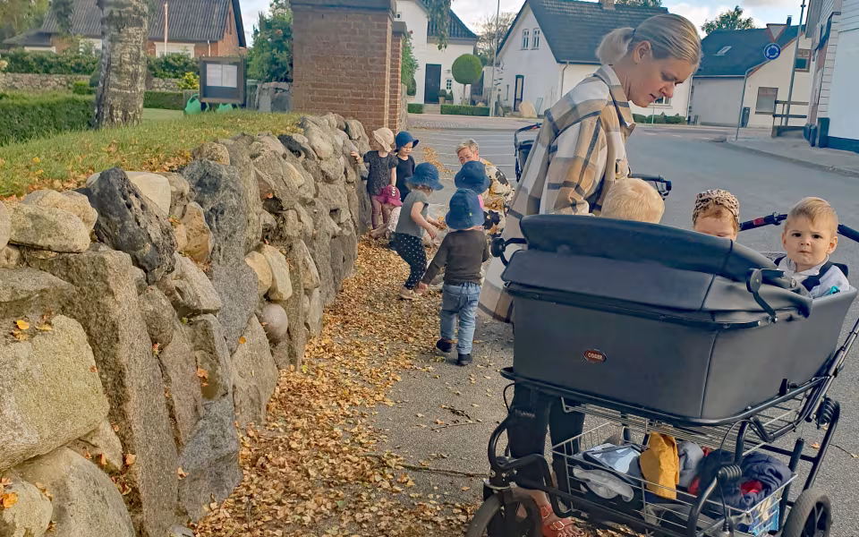 Børn fra Ansager dagpleje skaber et efterårsregn af birkeblade fra kirketræerne. Smil, latter og bare tæer dominerer i sanse-haven på denne dejlige sensommerdag