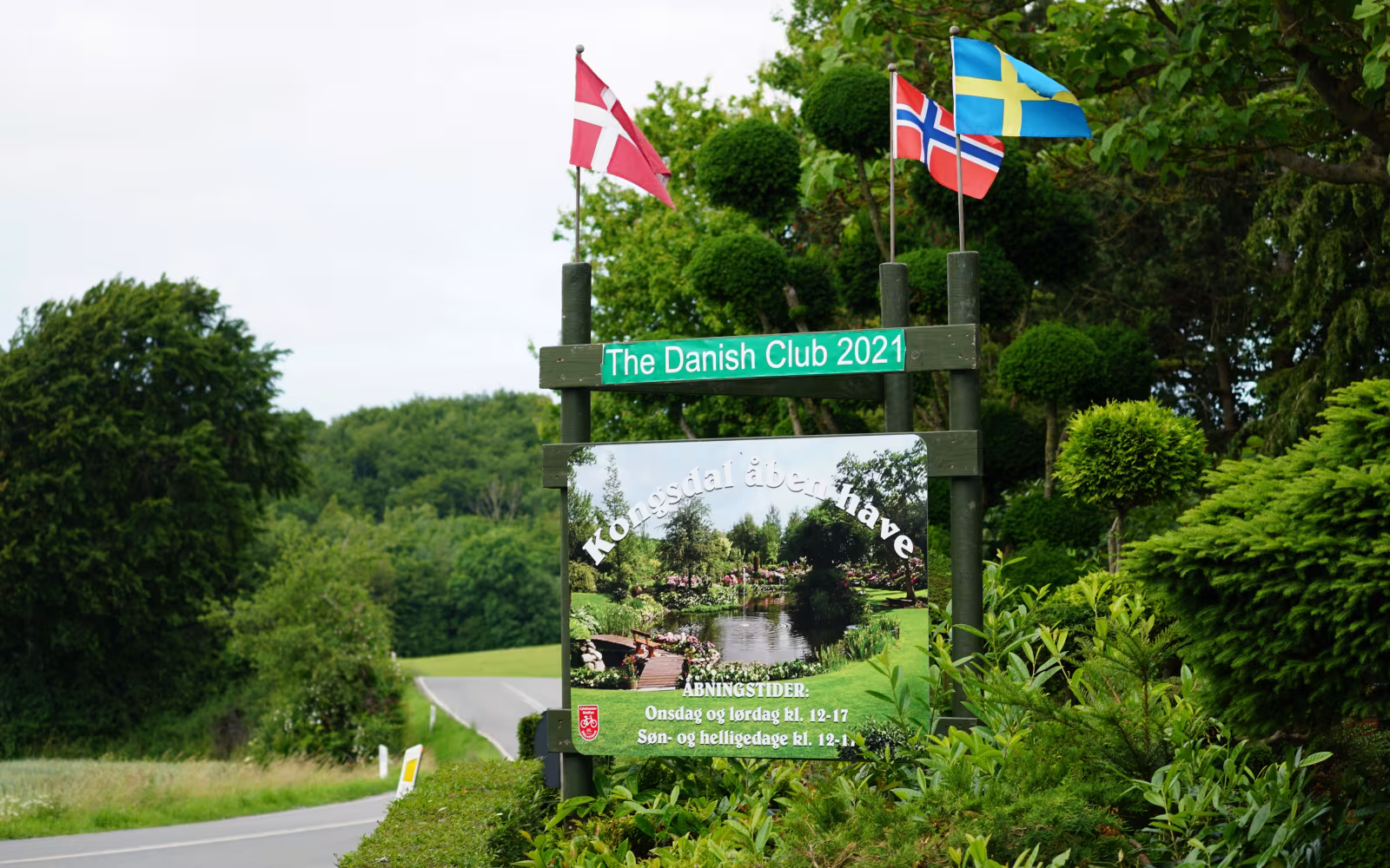 Skilt og nordiske flag ved indgangen til Kongsdal Åben Have