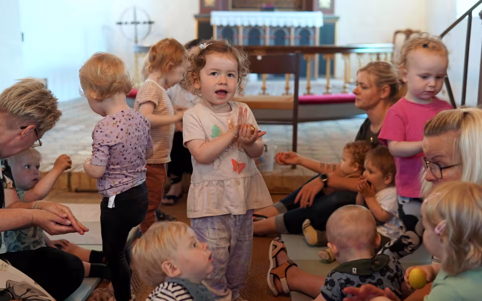 Musikforløb i Varde Kommunes dagpleje fokuserer på nærvær og gentagelser med enkle sange og rekvisitter. Her er vi i Ansager kirke og børn på forskellige udviklingstrin deltager.