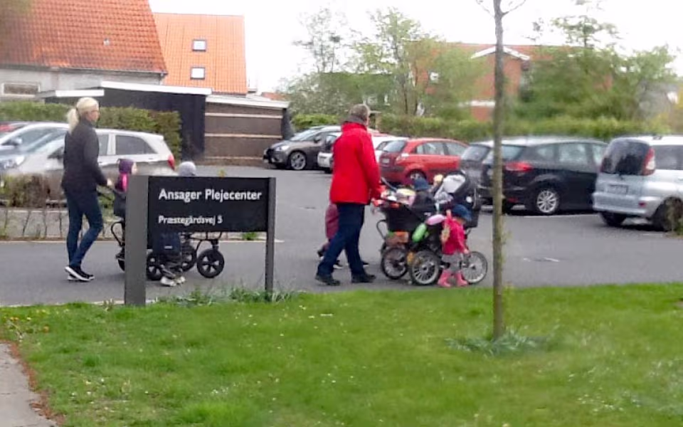 Dagplejen på tur rundt i byen med blomsterpyntede vogne