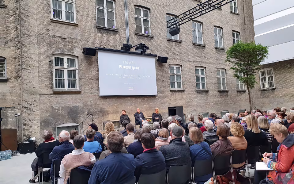Publikum lytter til forfatteroplæg på scenen ved Krimimesse i FÆNGSLET