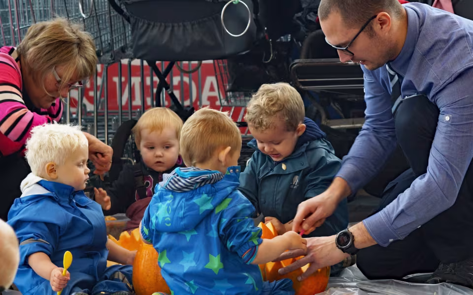 Dagplejebørn pynter til halloween i brugsen
