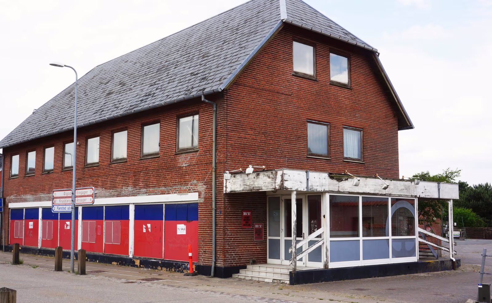 Den gamle brugsbygning står og forfalder mere og mere midt i Skovlund by. Nu er der mulighed for at få ruinen fjernet.
