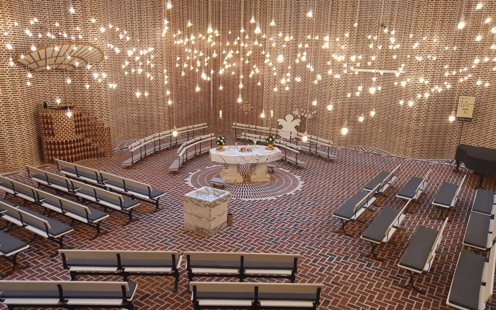 Lysekroner hænger over alter og bænke i Sædden Kirke
