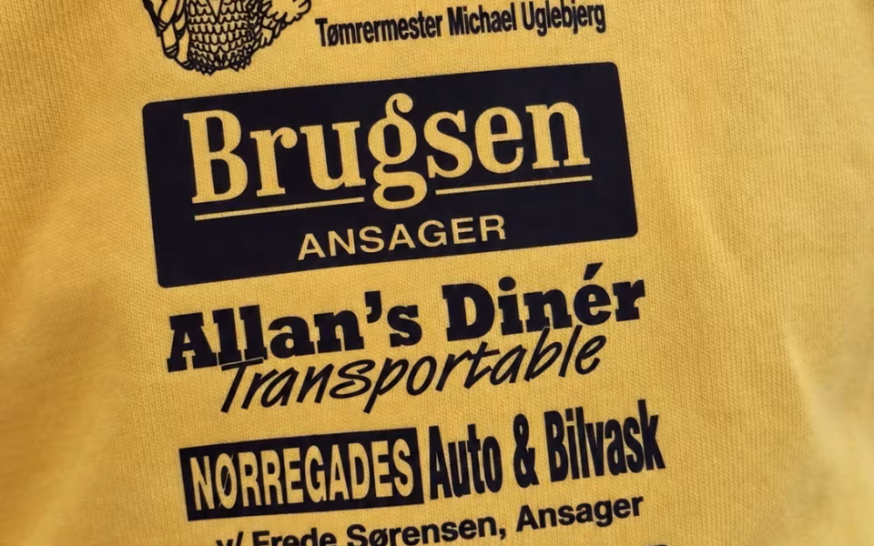Dagplejere og børn mødes til bevægelse i Skovlund-Ansager Hallen, hvor de nye gule trøjer er i brug blandt farverige redskaber.