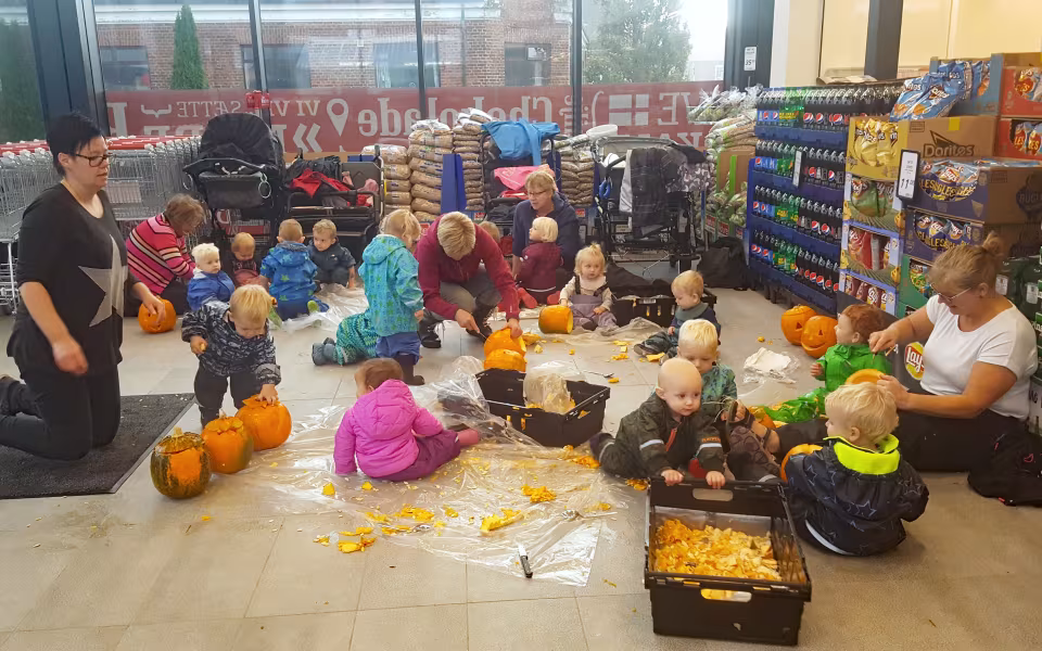 Dagplejebørn pynter til halloween i brugsen