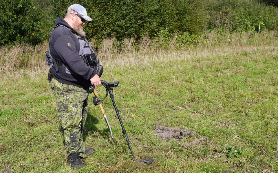 Per Olsen fandt lørdag en mortergranat med sin metaldetektor på marken mellem Tiphedevej og Kvie Søvej. En af bomberydderne viser granaten frem.