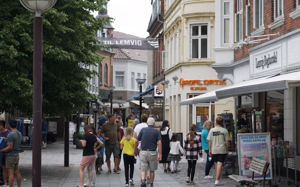 Gågade i Lemvig bymidte med handlende, butikker og banner mellem facader
