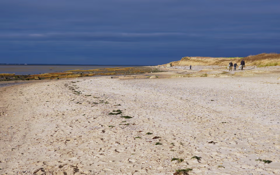 Strand ved Hjerpsted Strand med klitter, lavvande og mørke skyer