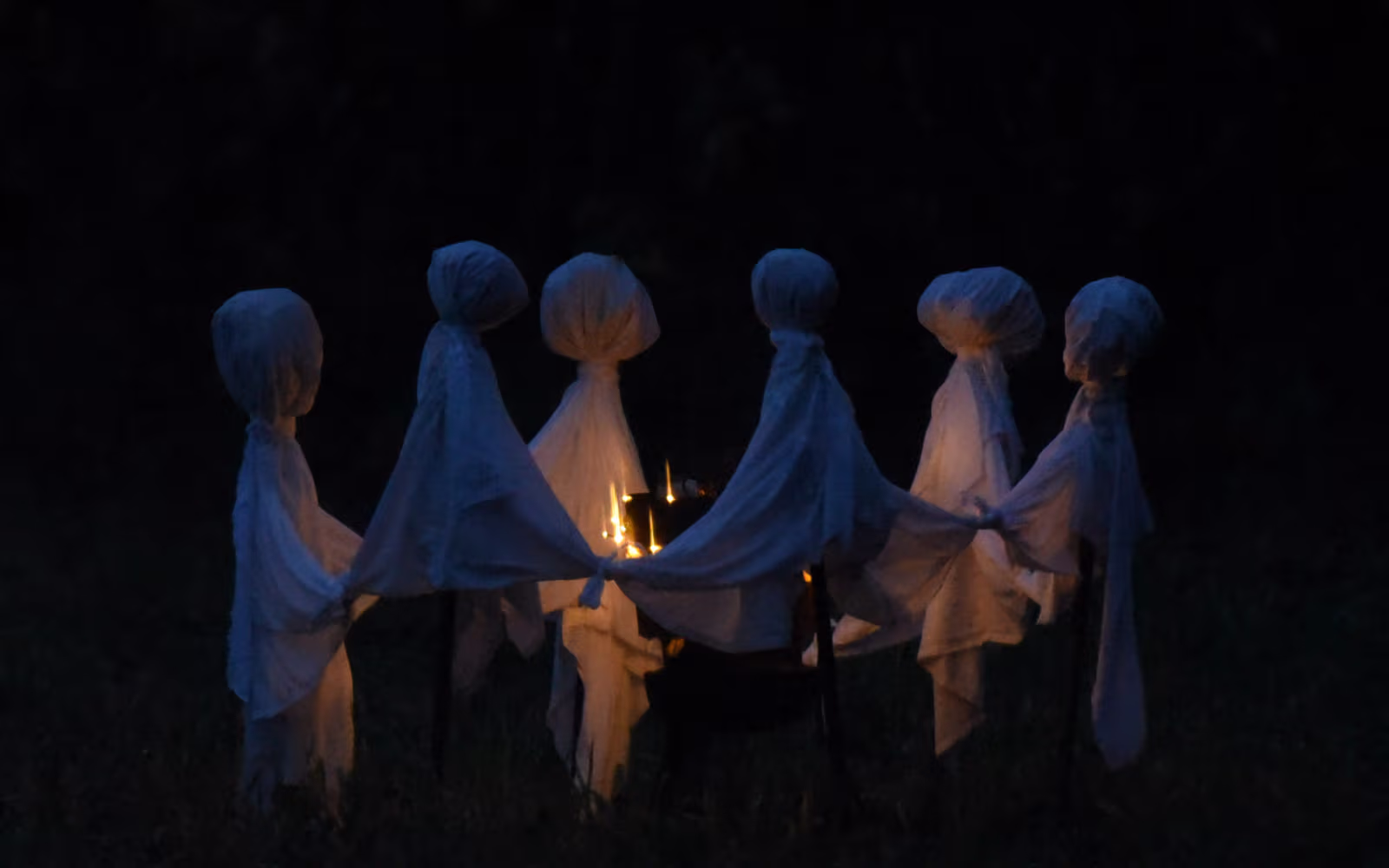 Spøgelsesfigurer i kreds om lys ved drive-in halloween i Gulddalslund Plantage