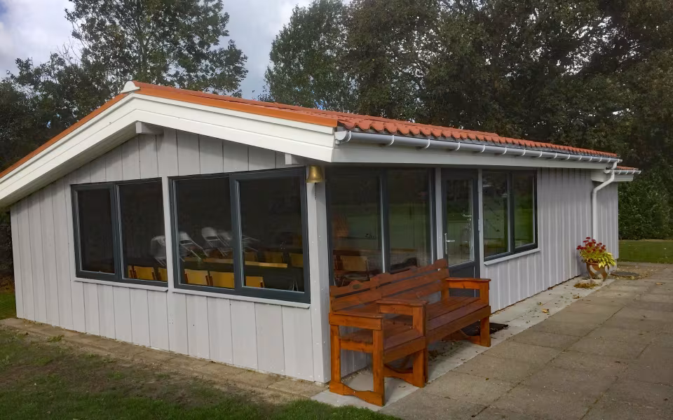 En del af bestyrelsen, Boje Østergård og Chris Hansen foran krocketklubbens nyrenoverede klubhus