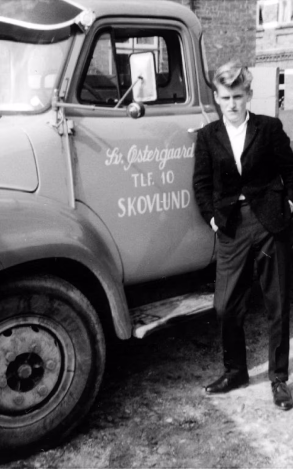 Mand står foran lastbil med Skovlund-tekst i Skovlund