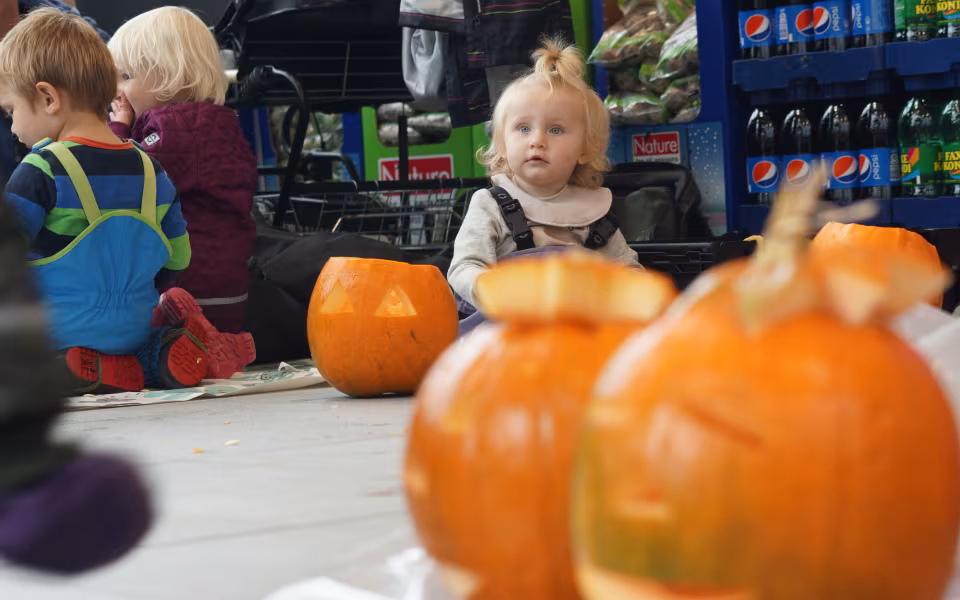Dagplejebørn pynter til halloween i brugsen