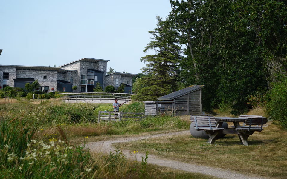 Mand med langt net ved Ganer Å akvarium foran grå murstensbygninger