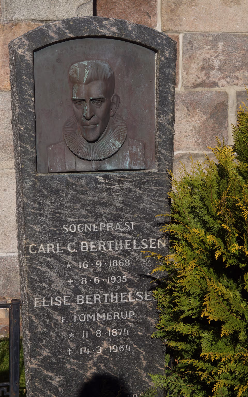 Gravsten med bronzerelief af præst ved Lunde Kirke