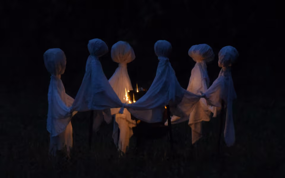 Spøgelsesfigurer i kreds om lys ved drive-in halloween i Gulddalslund Plantage