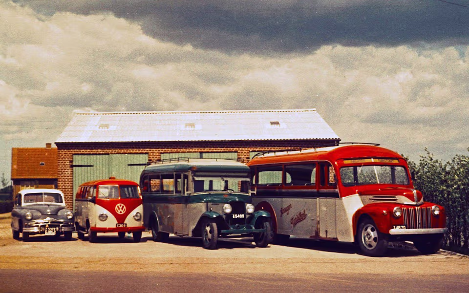 Veteranbusser og gamle biler holder foran Ansager Turists garage