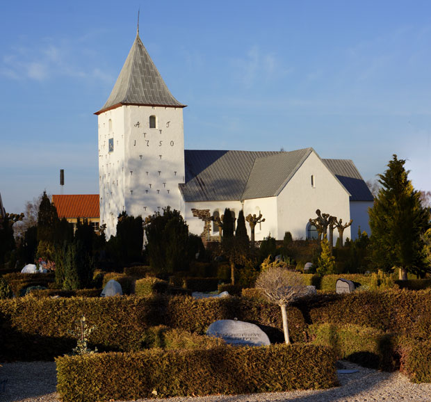 Ansager Kirke med det hvide tårn mellem grønne træer