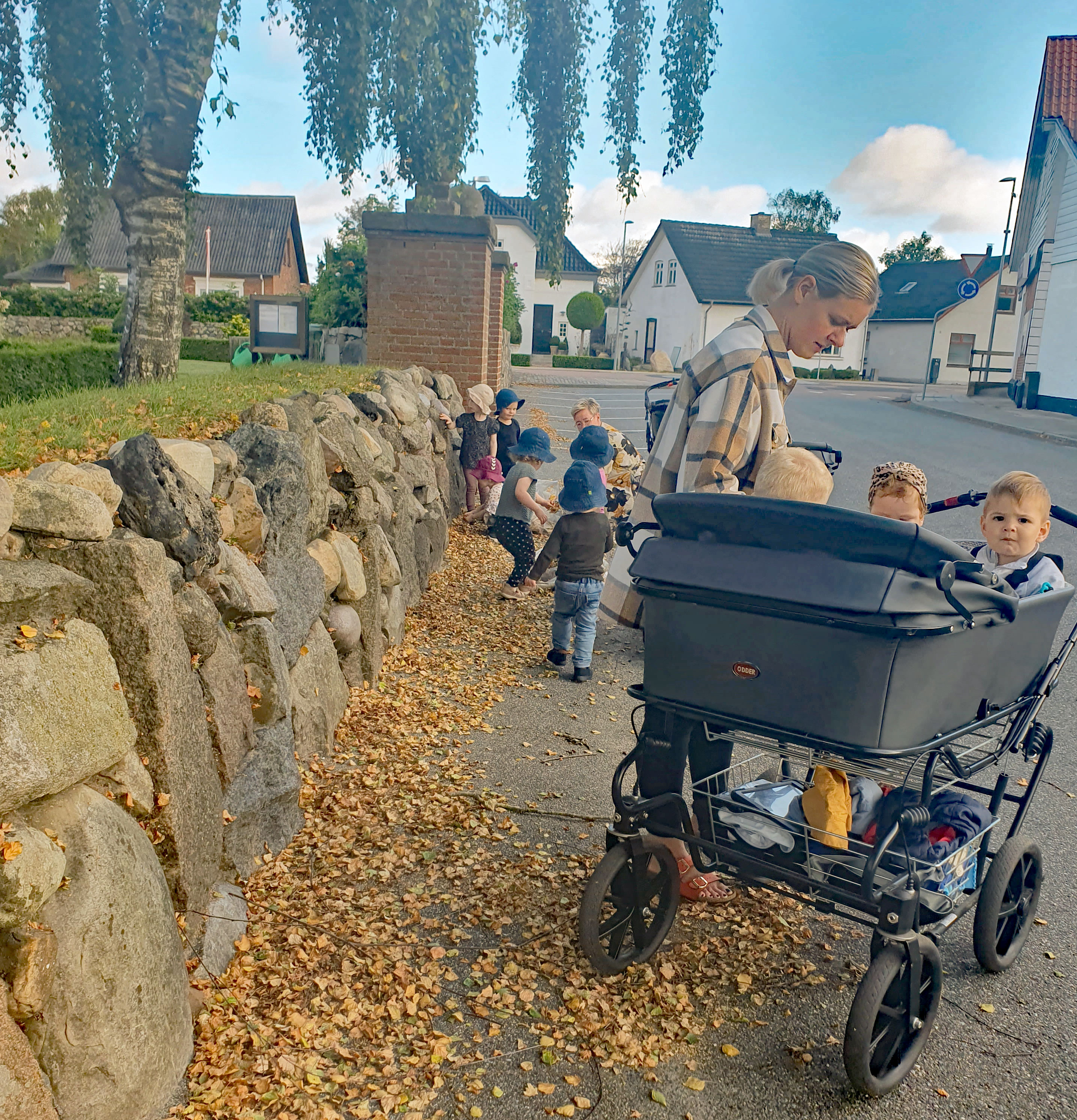Børn fra Ansager dagpleje skaber et efterårsregn af birkeblade fra kirketræerne. Smil, latter og bare tæer dominerer i sanse-haven på denne dejlige sensommerdag